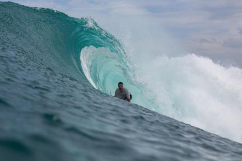 a man riding a wave on a surfboard in the ocean at Krui Surfing in Wainapal