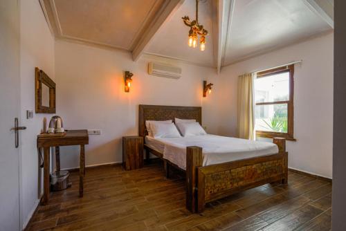 een slaapkamer met een bed, een tafel en een raam bij Belong Butik Otel in Çeşme