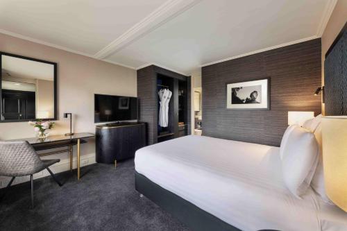 a hotel room with a bed and a desk at Pullman Auckland Hotel & Apartments in Auckland