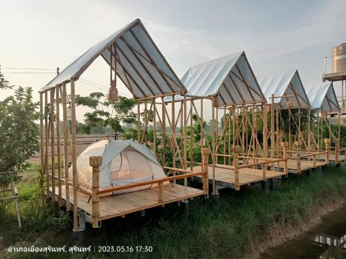 a row of tents on the side of a river at สวนเกษตรรักษ์ไผ่ Bamboo Conservation Farm in Surin