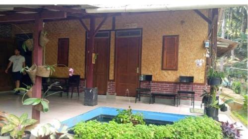a house with a swimming pool in front of it at Ijen Farmer Homestay in Banyuwangi