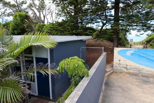 a house with a swimming pool next to a fence at Hoey Moey Backpackers in Coffs Harbour