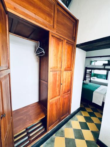 a room with a wooden cabinet and a bedroom at Green Door San Gil in San Gil