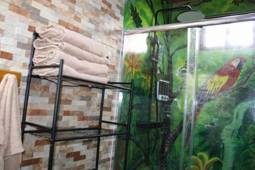 uma casa de banho com um chuveiro e uma pintura na parede em Casa Cabaña En San Carlos Panamá em San Carlos