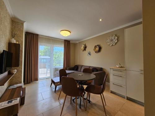 a living room with a table and chairs and a kitchen at Sakura_INN Palanga in Palanga