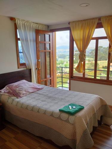 1 dormitorio con cama y ventana grande en Finca Bella Vista Posada Rural, en Toca