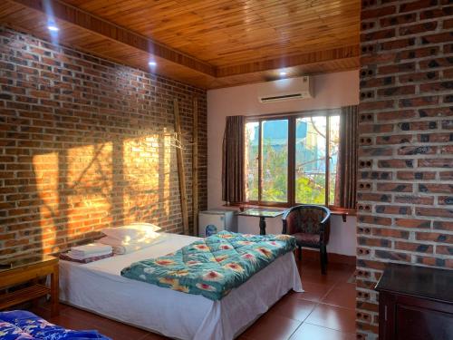 a bedroom with a bed and a brick wall at Nhà hàng-Khách sạn Hồ Núi Đính in Ninh Binh