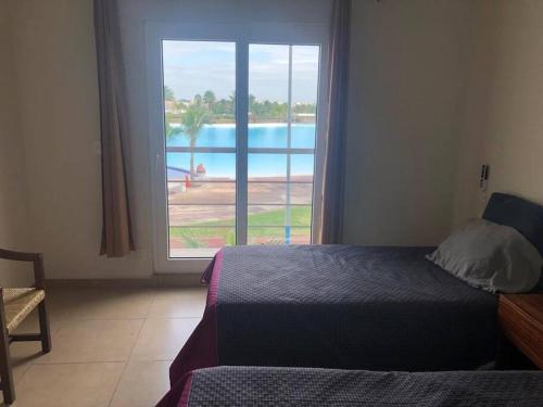 a bedroom with a bed and a view of a pool at Departamento, Laguna y Albercas en Dream Lagoons Veracruz in Veracruz