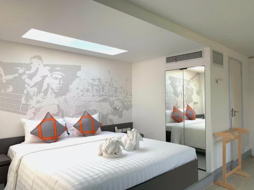 a bedroom with two beds and a mirror at Tao Resort and Villas (SHA Extra+) in Phuket Town