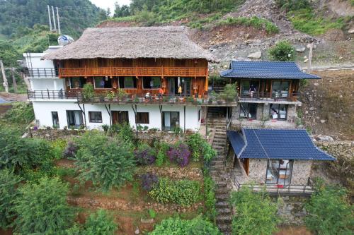 una casa con techo de paja en una colina en Dong Suoi H'mong Homestay & Bungalow en Mù Cang Chải