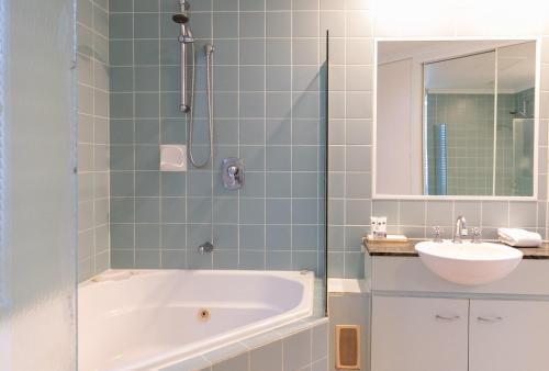 a bathroom with a tub and a sink at Beaches Holiday Apartments - Official Onsite Reception & Check In in Port Douglas