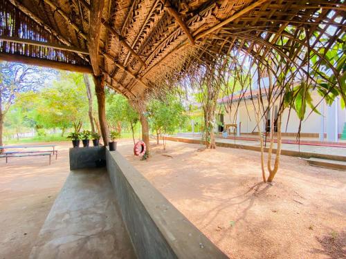 Ima Villa Sigiriya في سيجيريا: جناح فيه اشجار ومقعد في حديقة