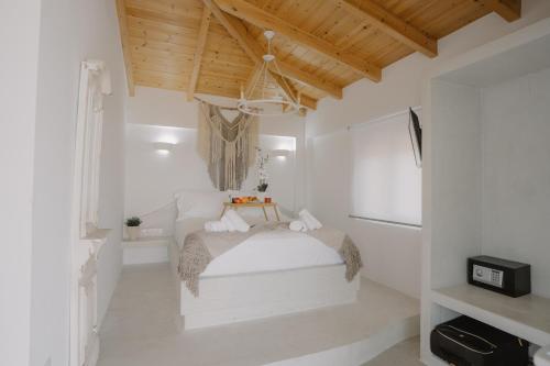 1 dormitorio con 1 cama en una habitación blanca en MIRAMAR KARYSTOS en Karistos
