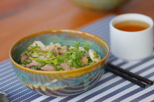 a bowl of food on a table with a cup of tea at Leaf Hotel Phu Quoc in Phu Quoc