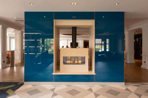 a living room with a fireplace in a blue wall at Holiday Inn Guildford by IHG in Guildford