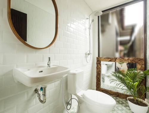 a bathroom with a sink and a toilet and a mirror at Rainnan Kallih - 3 bedroom Villa near Bali Safari in Keramas