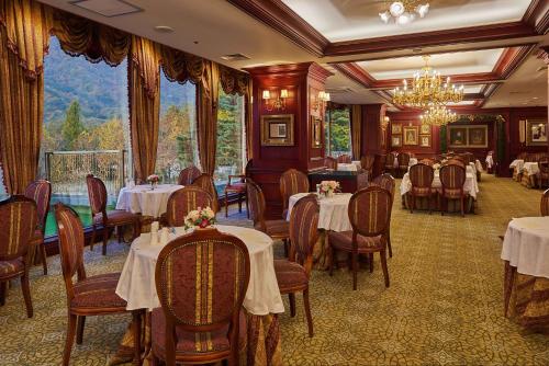 a restaurant with tables and chairs and a chandelier at KensingtonHotel Seorak in Sokcho