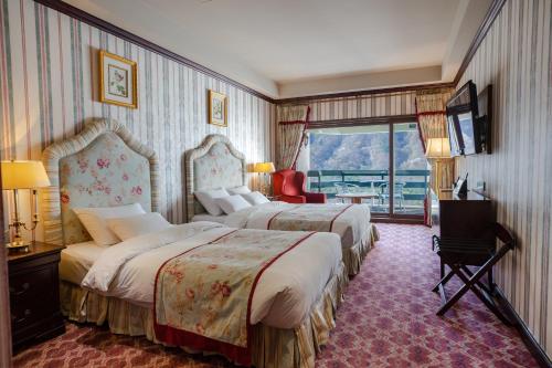 a hotel room with two beds and a balcony at KensingtonHotel Seorak in Sokcho
