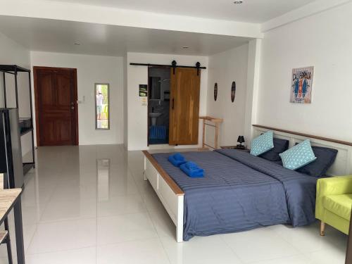 a bedroom with a large bed with blue pillows at Skipper's Karon in Karon Beach