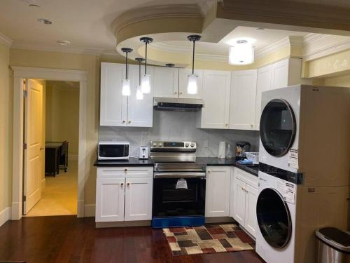 a kitchen with white cabinets and a stove top oven at spacious modern new suite in Vancouver