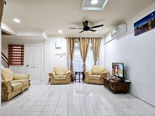 a living room with chairs and a ceiling fan at Sapphire Residence in Jenjarum