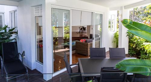 a dining room with a table and chairs on a patio at Beaches Holiday Apartments - Official Onsite Reception & Check In in Port Douglas