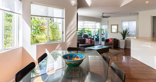 a dining room and living room with a glass table and chairs at Beaches Holiday Apartments - Official Onsite Reception & Check In in Port Douglas
