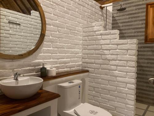 a bathroom with a toilet and a sink and a mirror at Hotel La Costa International Salango in Puerto López