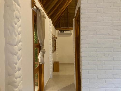 um corredor de uma casa com paredes brancas e tectos de madeira em Hotel La Costa Salango em Puerto López