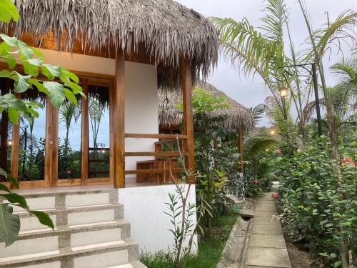 a small house with a thatch roof at Hotel La Costa International Salango in Puerto López