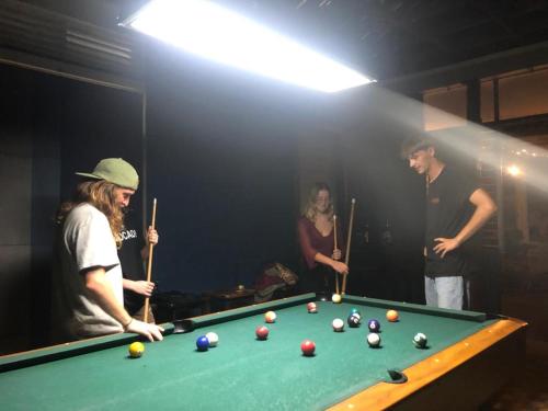 a group of people playing pool in a room at Hostel ZwiebeL in Santa Ana