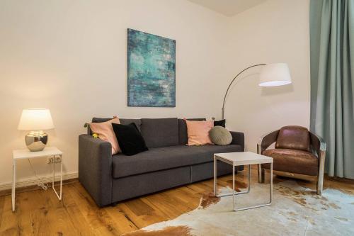 a living room with a gray couch and a chair at Insel Chalet Lindau in Lindau