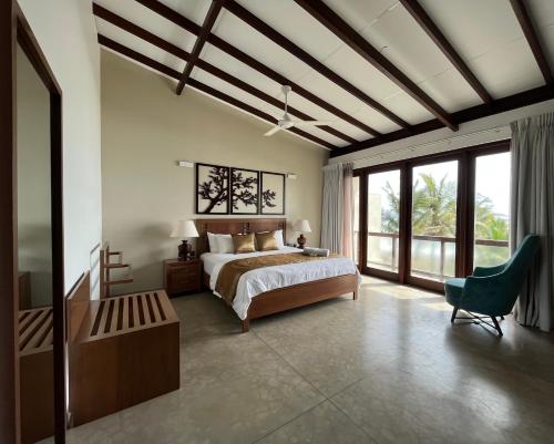 a bedroom with a bed and a large window at Driftwood Villa in Pamunugama