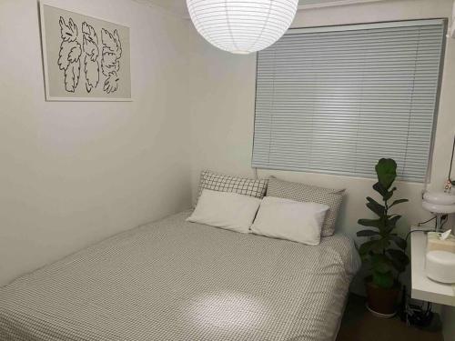 a bedroom with a bed with two pillows and a window at NEW 2F super cozy 2BR 5min station stay contigo in Seoul