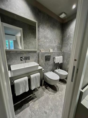 a bathroom with a sink and a toilet and a mirror at The Upper House in Riomaggiore