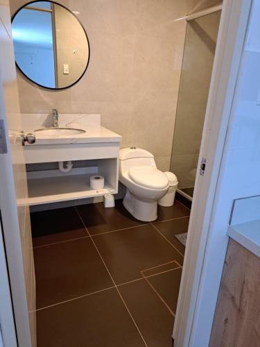 a bathroom with a toilet and a sink and a mirror at Venue Studios in Lima