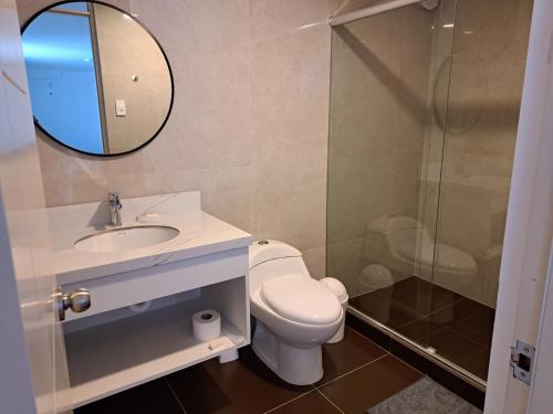 a bathroom with a toilet and a sink and a mirror at Venue Studios in Lima