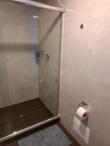 a shower with a glass door and a roll of toilet paper at Venue Studios in Lima