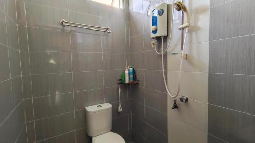 uma casa de banho com um WC branco e um chuveiro em Homestay Baitus Soleh Batu Buruk em Kuala Terengganu