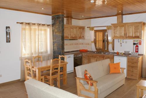 a kitchen with a couch and a table in a room at Casa da Eira em Dornes - Casa de campo familiar com piscina in Dornes