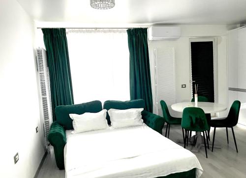 a bedroom with a bed and a table with chairs at Studio Philip by Alezzii Nord 10 in Năvodari