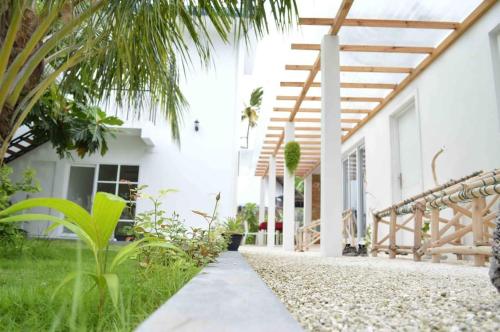 a house with a pathway leading to the front yard at Small Island Lodge in Vaadhoo