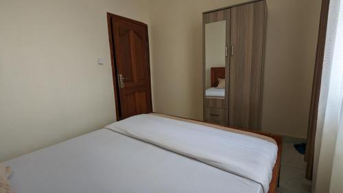 a small bedroom with a bed and a mirror at Star Max Apartments in Kigali