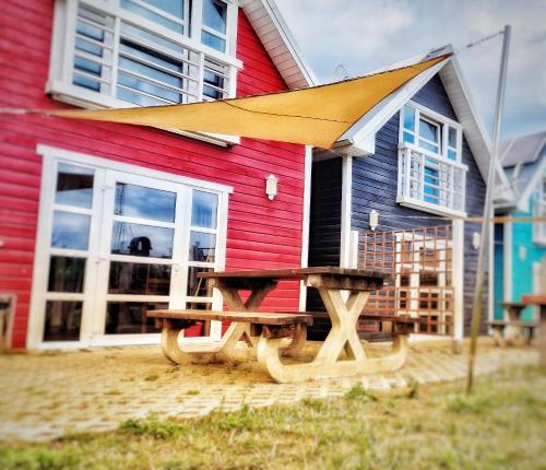 a picnic table in front of a colorful house at Domki Primore in Władysławowo