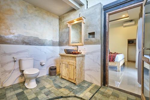 a bathroom with a toilet and a sink at Arungan Villas in Amed