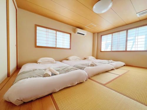 uma fila de camas num quarto com janelas em 千間川ー天王寺 em Osaka