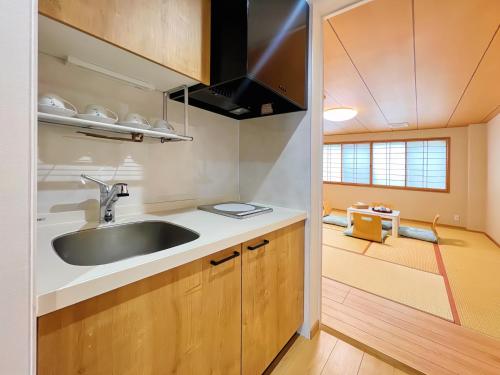 uma cozinha com um lavatório num pequeno quarto em 千間川ー天王寺 em Osaka
