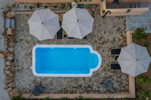 an overhead view of a swimming pool with umbrellas at Villa Akulica in Jakišnica