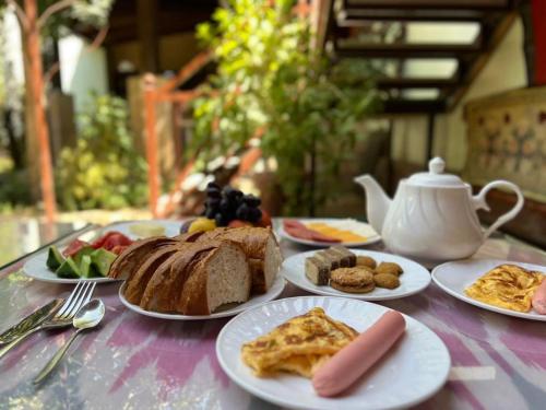 a table with plates of breakfast food on it at Green House ECO HOTEL in Samarkand