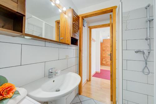 a white bathroom with a sink and a mirror at Studio Clotes Ski In - Ski Out - Happy Rentals in Sauze dʼOulx